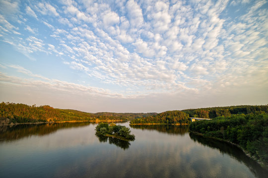 Colourful sunset over a lake. Summer scene of wide river landscape with setting sun.