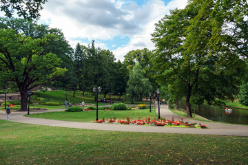 People in Summer public park with flower bed in Riga, Latvia, July 25, 2018
