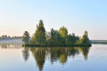 Fototapeta na wymiar Small island in lake at sunset.