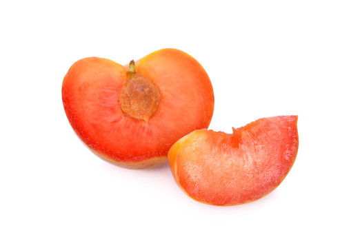 half and sliced fresh pluot on white background