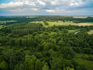 Obraz premium A beautiful view of the forest, fields and river from above. Drone photography 