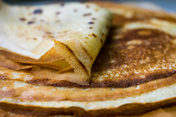 Appetizing golden pancakes with crispy crust, cooked at home. Fatty and hot pancakes on milk