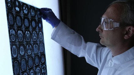 Senior doctor looking at chest x-ray in office. - Powered by Adobe