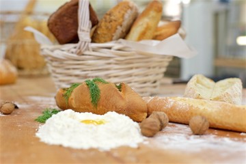 Many mixed breads in wicker basket on the table