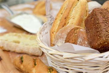 A lot variety breads in wicker basket on the table at commercial bakery kitchen