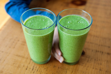 Fresh green healthy smoothie in sunlight on wooden background. 