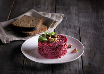 beet salas with garlic and nuts on the wooden table in rustic style