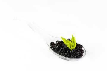 Plastic spoons with fish caviar on a white background. 