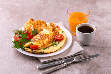 Herb omelette with tomatoes and panini toasts. Coffee. Breakfast