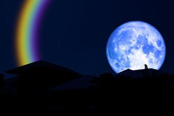 Fototapeta na wymiar full blue moon halo back over silhouette roof