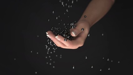 black balls fall into the hand - Powered by Adobe