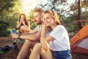Party, camping of men and women group at forest. They relaxing against green grass. The vacation, summer, adventure, lifestyle, picnic concept