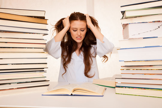 attractive young woman student undre stress while studiing for exames