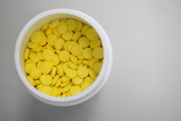 yellow medicine pills in can top view