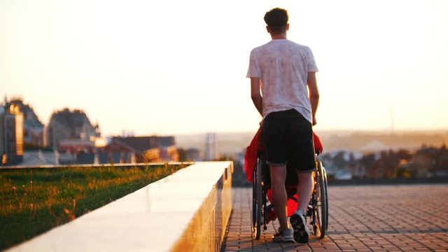 Young Man Rolls Disabled Girl With Red Hair, Tells And Shows His Hand