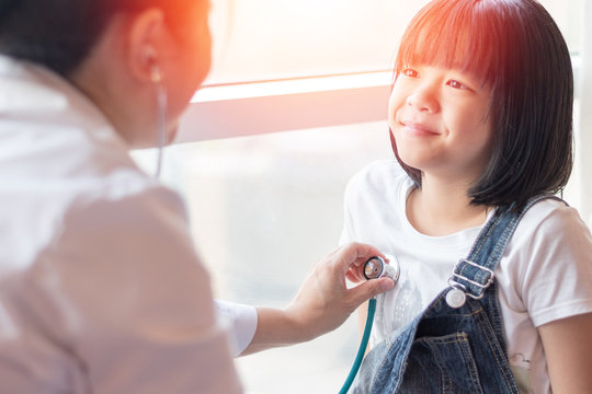 Professional general medical pediatrician doctor in white uniform gown listen lung and heart sound of Asia child patient with stethoscope: Physician check up Asian kid female after consult in hospital