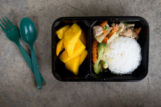 Rice and vegetables served with mango in lunch box