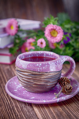 Fruit tea, books and flowers asters on a wooden background