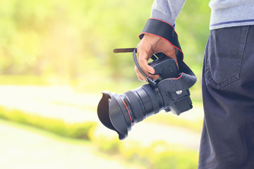 Photographer holding DSLR camera in his hands, Travel lifestyle vacations concept