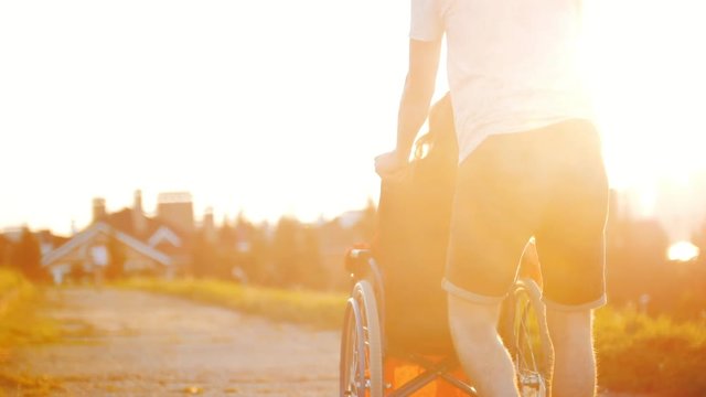 Guy Rolls Girl In A Wheelchair On A Summer Evening In The Sunset