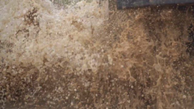 Extreme driving conditions in the countryside. A powerful SUV drives into a deep puddle. Flying splashes and dirt. Beautiful car in rough terrain.
