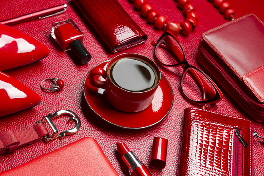 Woman red accessories with coffee, cosmetic, jewelry,  gadget and other luxury objects on leather background, fashion industry, modern female concept, selective focus 
