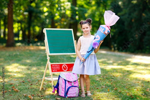 Happy Little Kid Girl By Desk With Backpack Or Satchel And Big Happy Little Kid Girl By Desk With Backpack Or Satchel And Big School Bag Cone
