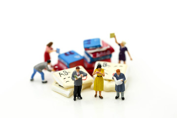 Miniature people : reading a book using as background education or business concept.