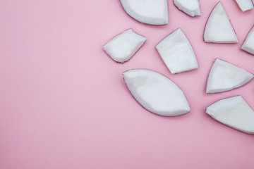 Tropical summer coconut pieces on a pastel pink background.