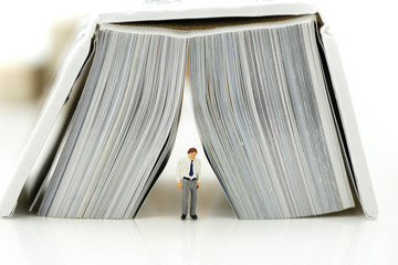 Miniature people : reading a book using as background education or business concept.