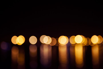 Blurred city lights with bokeh effect reflected on water