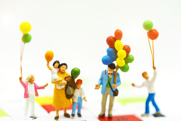 Miniature people children holding balloon with sunlight, happy family day concept.