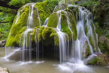 Beautiful unique Bigar Waterfall in Romania on the Edge of the Road passing through the carpatian Mountains