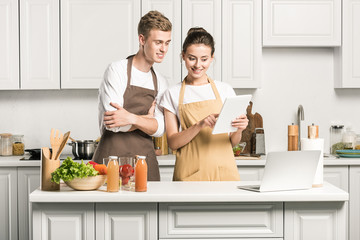 young couple looking at tablet in kitchen
