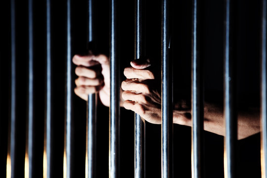 close up of prisoner hands in jail.