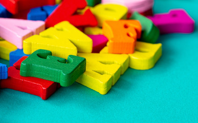 closeup of colorful wooden alphabet on green background.