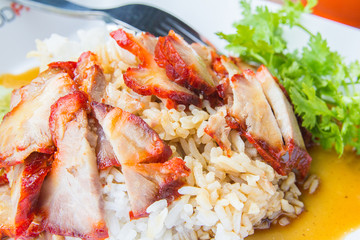 Barbecued red pork in sweet sauce with rice and cucumber on table