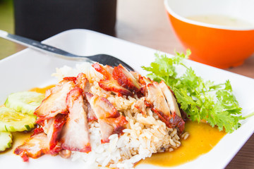 Barbecued red pork in sweet sauce with rice and cucumber on table © PhotoJuthamat