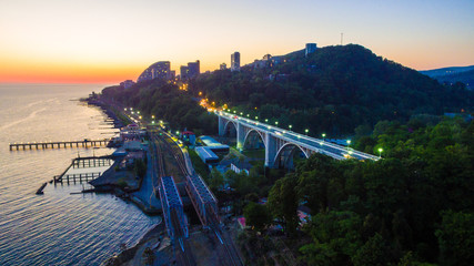 Drone view of the seaside with the railway, the illuminated Matsesta viaduct and mountains with...