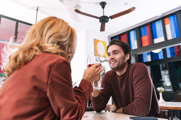 Romantic evening. Low angle of nice positive couple drinking wine and speaking
