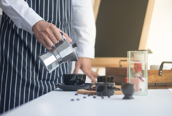 barista man holding cup of hot coffee to drink in cafeteria with copy space for text on advertisement board