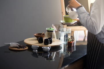 barista man holding cup of hot coffee to drink in cafeteria with copy space for text on advertisement board