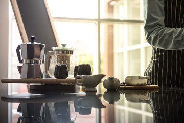 barista man holding cup of hot coffee to drink in cafeteria with copy space for text on advertisement board