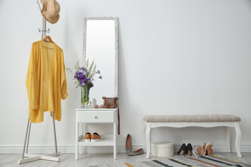 Stylish hallway interior with mirror and rack