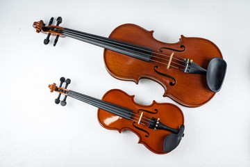 Fototapeta na wymiar Two violins put on white background,show the different size of violin.