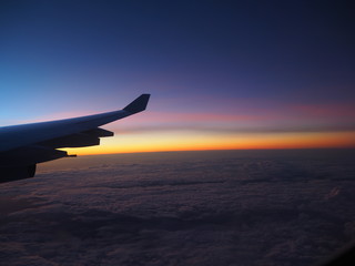 View from an airplane window to see the sky in the evening time at sunset in beautiful colors.