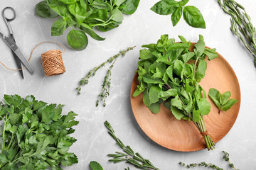 Flat lay composition with fresh green herbs on grey background