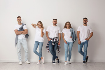 Obraz premium Group of young people in jeans near light wall