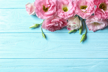 Flat lay composition with beautiful Eustoma flowers on wooden background