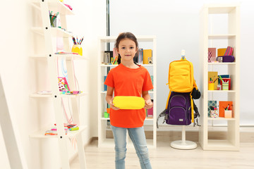 Cute child choosing school stationery in store